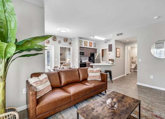 A living room with a brown leather couch and a coffee table.