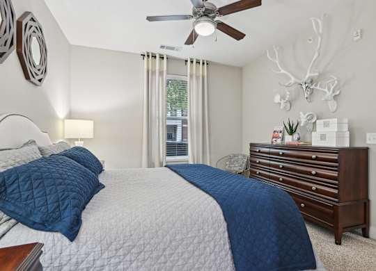 A bedroom with a large bed and a ceiling fan.