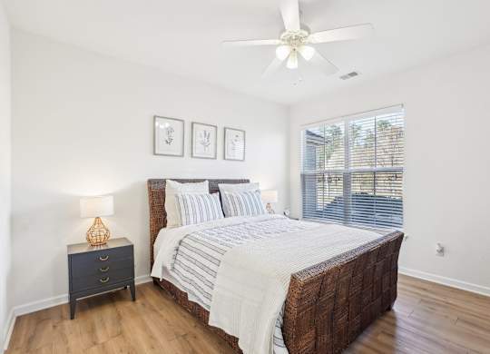 A bedroom with a large bed and a ceiling fan.
