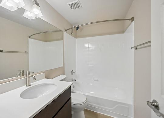 A white sink is on a countertop in a bathroom.