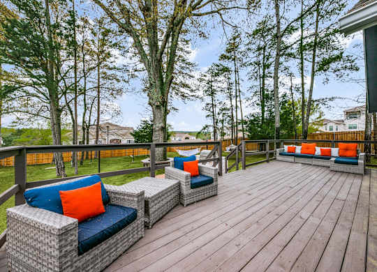 a large deck with furniture on it and trees