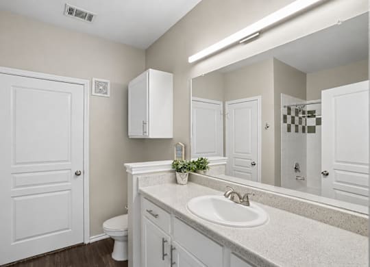 A bathroom with a white sink and a white toilet.