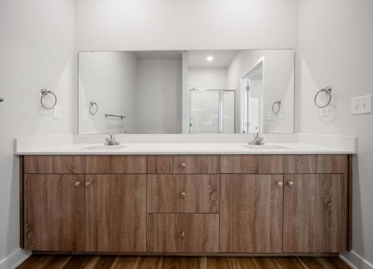 A bathroom with a wooden vanity and a large mirror.