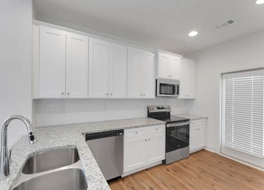 A kitchen with white cabinets and stainless steel appliances.