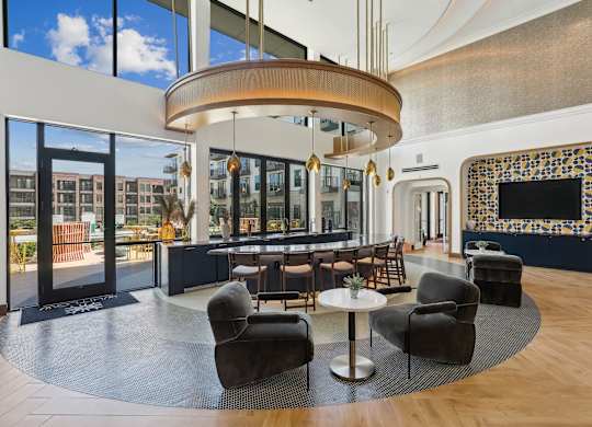 A modern living room with a large circular light fixture and a fireplace with a mosaic tile surround.