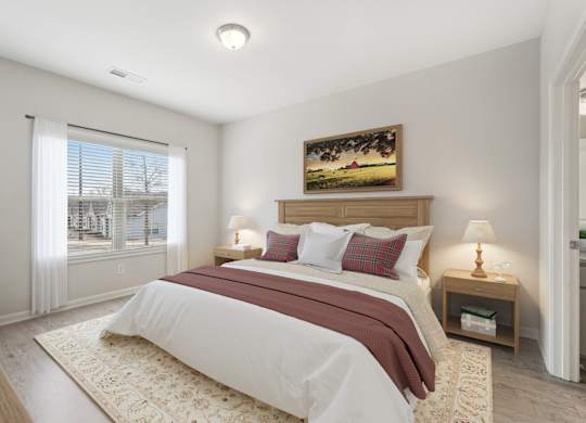 A bedroom with a large bed and a painting on the wall.