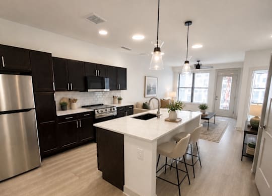 A modern kitchen with a center island and pendant lights.