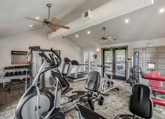 a home gym with exercise equipment and ceiling fans