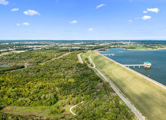 A bridge spans a body of water with a green landscape on either side.