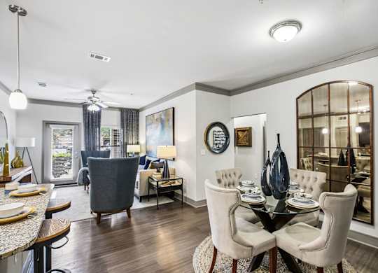 A dining room with a table set for two and a view of the backyard.