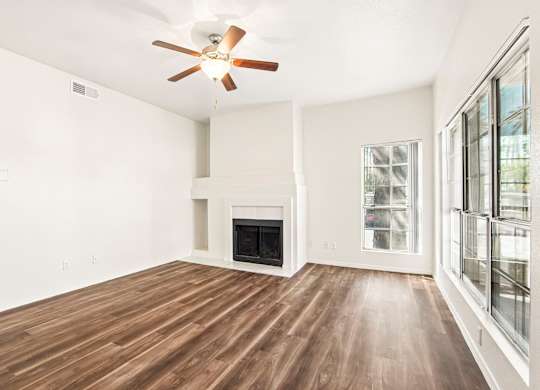A room with a fireplace and wood flooring.