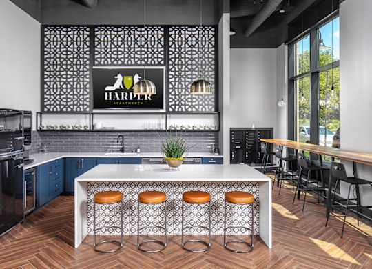 a kitchen with a large center island with stools in front of it at Harper Apartments in St Paul, MN
