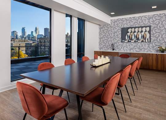 a dining room with a table and chairs and a view of the city