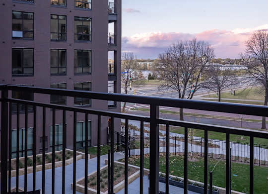 a balcony with a view of a building and a fence