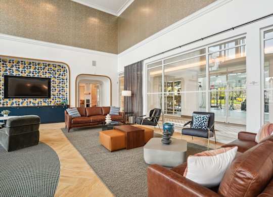 A living room with a brown leather couch and a television.