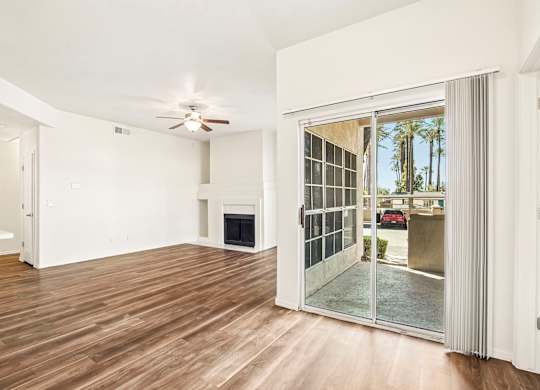 A room with a fireplace and a sliding glass door leading to a balcony.