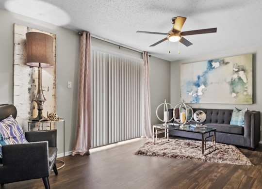 a living room with a ceiling fan and a sliding glass door