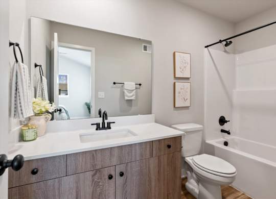 A bathroom with a white sink and a white toilet.