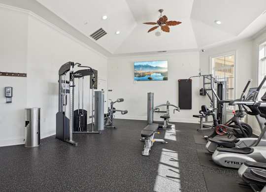 A spacious gym with a variety of equipment including treadmills, stationary bikes, and weight machines.