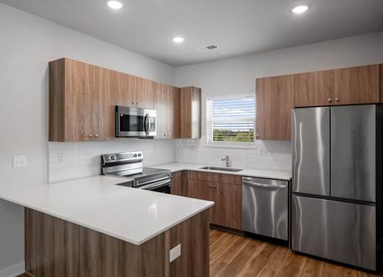 A modern kitchen with wooden cabinets and stainless steel appliances.