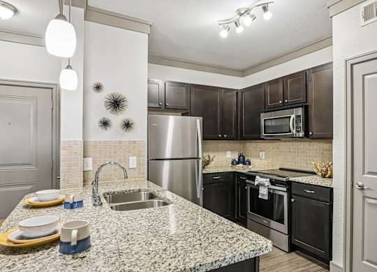 A kitchen with granite countertops and stainless steel appliances.