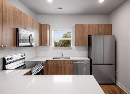 A modern kitchen with wooden cabinets and stainless steel appliances.