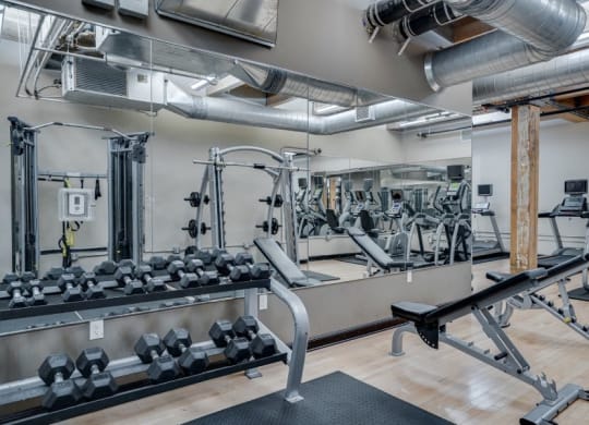 Gym with large mirrors and weights C&E Living in St Paul, MN