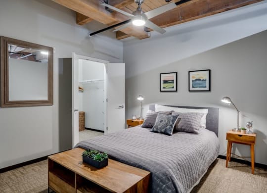 Loft style bedroom with exposed wood ceilings and walk-in closet