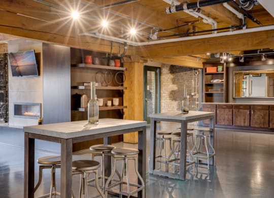 the kitchen and dining area of a loft with a bar and stools