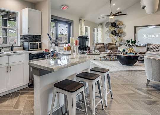 a kitchen and living room with stools and a counter