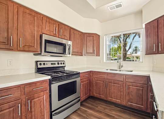 A kitchen with wooden cabinets and a stove top oven.
