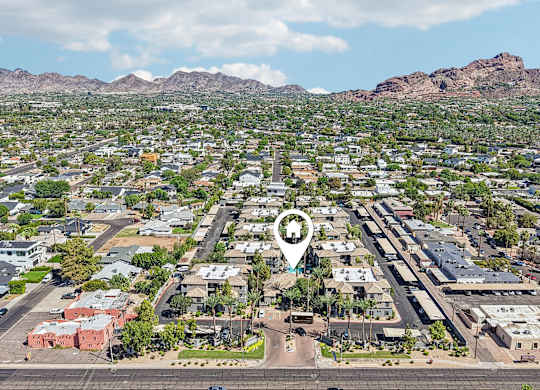 A bird's eye view of a residential area with a road running through the middle.