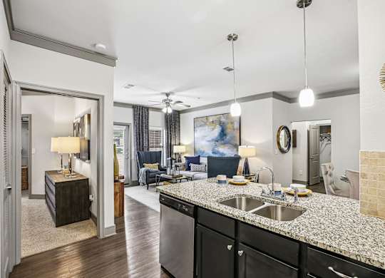 A modern kitchen with a marble countertop and a ceiling fan.