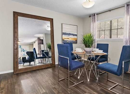 a dining room with a mirror and a table and chairs