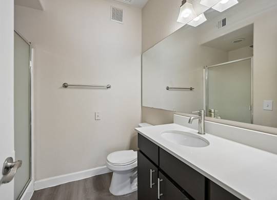 A bathroom with a toilet, sink, and mirror.