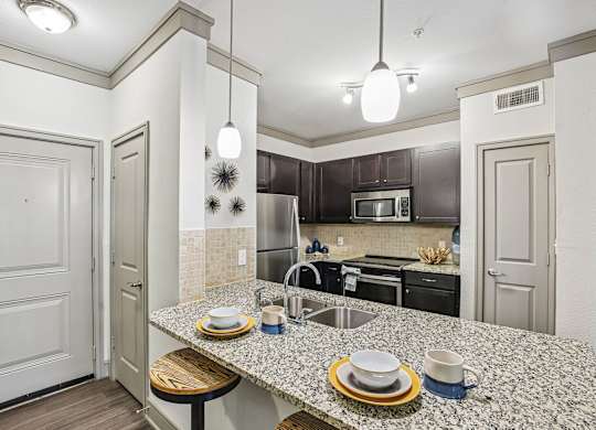 A kitchen with a granite countertop and a sink.
