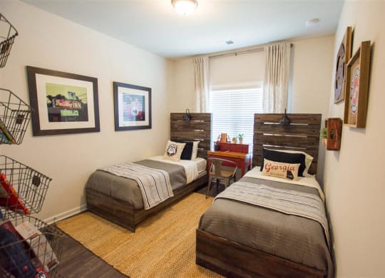 a bedroom with two beds and a table and a window