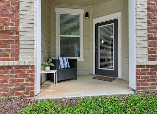A small porch with a bench and a door.