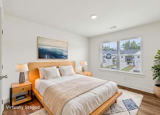 A bedroom with a large bed and a painting on the wall.