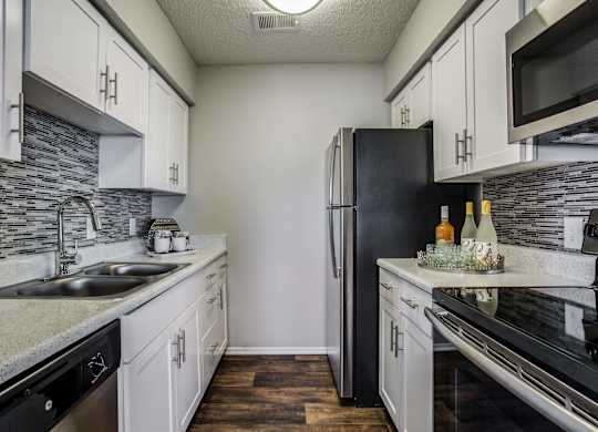 a kitchen with stainless steel appliances and white cabinets