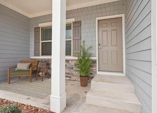 A house with a grey front porch and a white door.