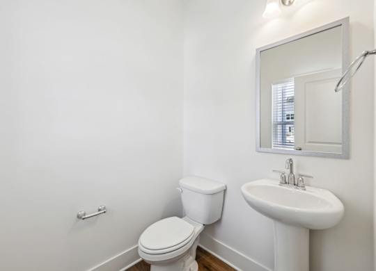 A white toilet and sink in a bathroom.