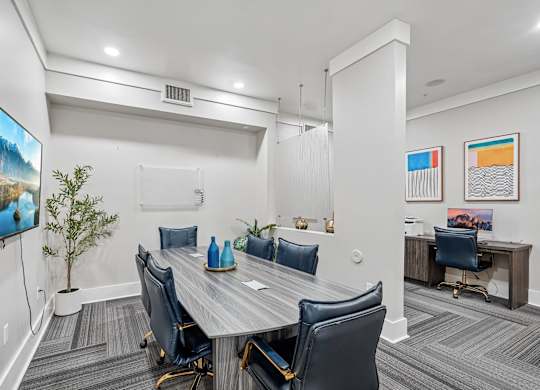 A conference room with a large table and chairs.
