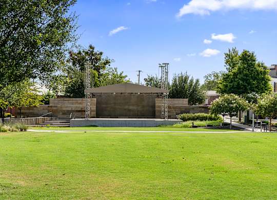 A large concrete structure sits in the middle of a grassy field.