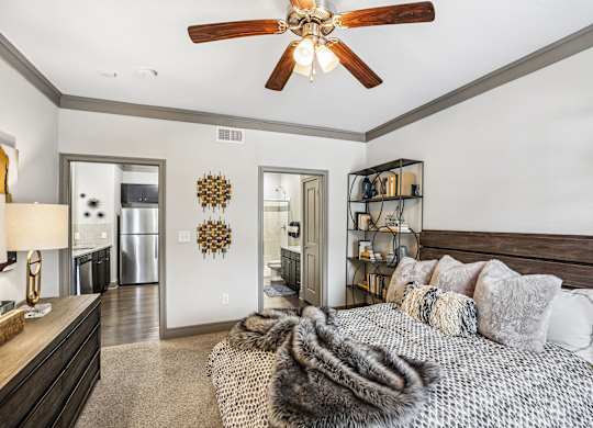 A bedroom with a large bed and a ceiling fan.