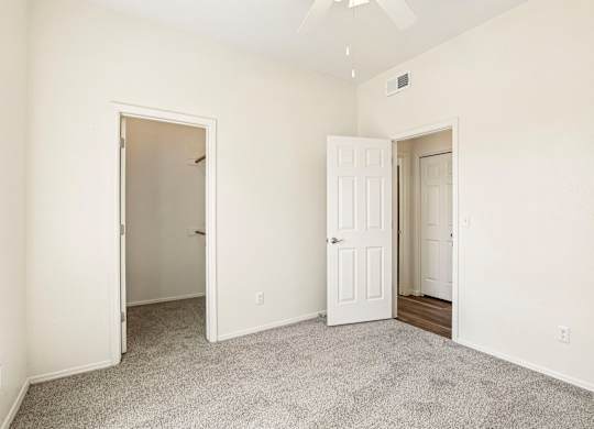 A room with two doors and a carpeted floor.