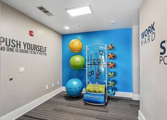 A gym room with a blue wall and a green ball.