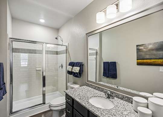A bathroom with a white toilet, sink, and mirror.