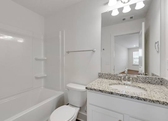 A white bathroom with a tub, toilet, and sink.