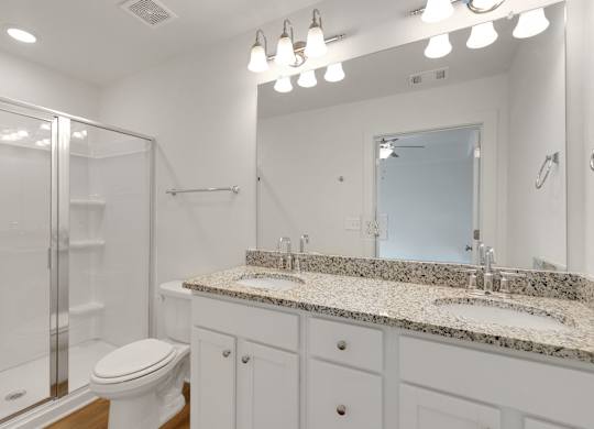 A bathroom with a toilet, sink, and mirror.